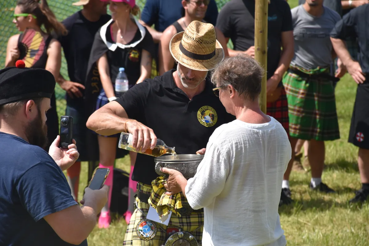 Ein Mann füllt Whiskey in einen Kelch.